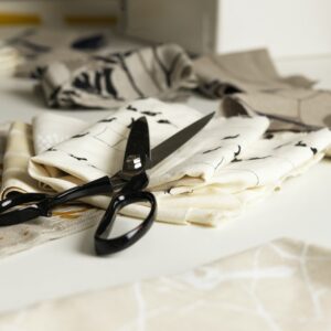 Pair of scissors and fabric on work table
