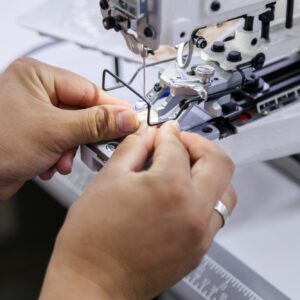 Tailor adding button to electric sewing machine
